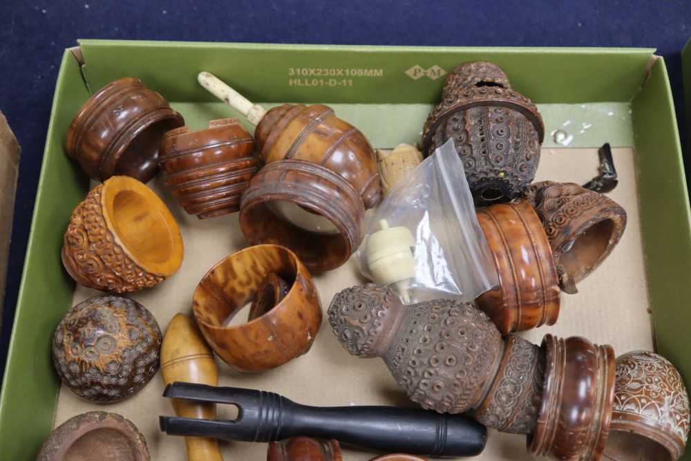 A 19th century ivory humming top, a coquilla nut humming top and a group of coquilla nut carvings and napkin rings